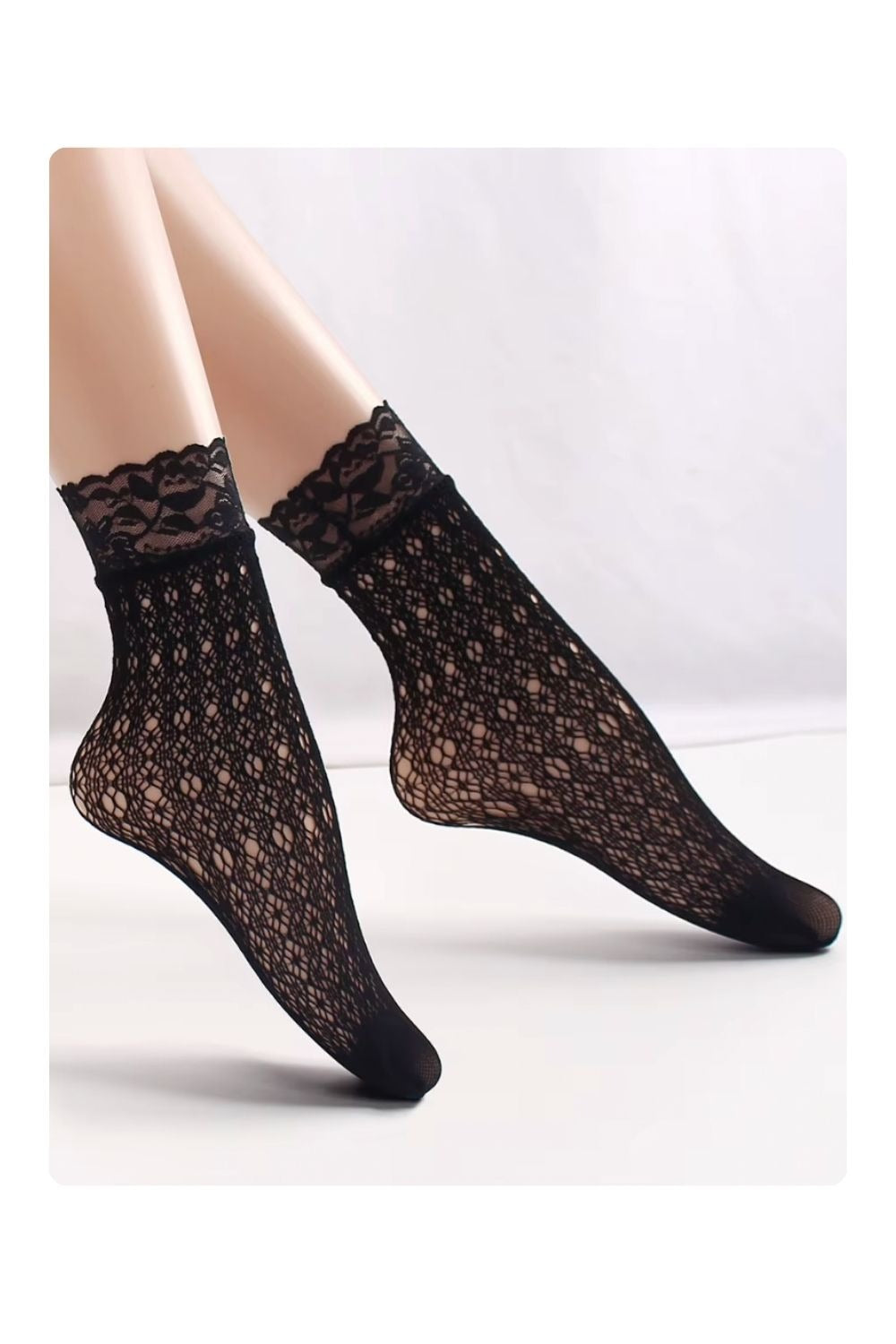 Black floral lace ankle socks with sheer mesh pattern and scalloped lace trim, styled on model legs, elegant feminine hosiery.
