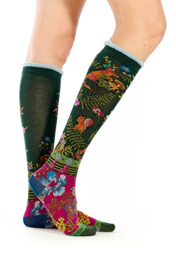 Woman wearing knee-high floral socks with colorful botanical pattern in green, pink, and blue 2