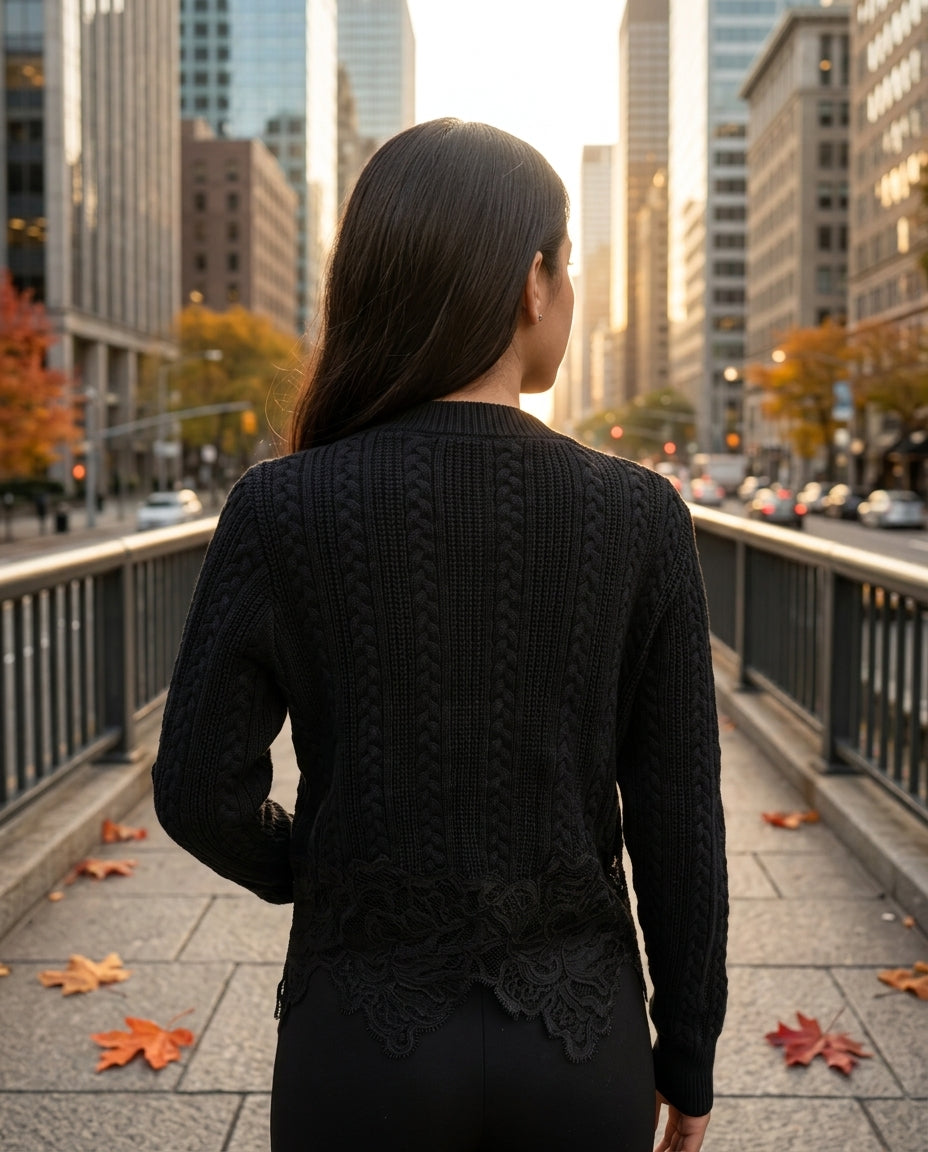 The Eloise Cardigan in black – back view showing cable knit and lace hem